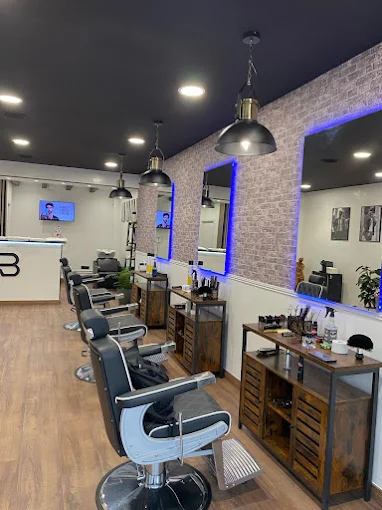 Interior de Alexander's Barbershop — sillas de barbero y luces LED azules